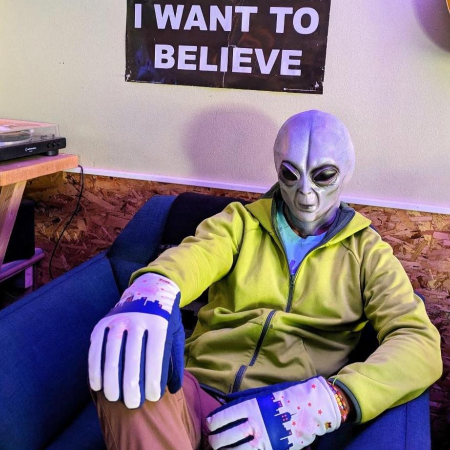 Alien wearing UFO Freezy Freakies below I want to believe poster
