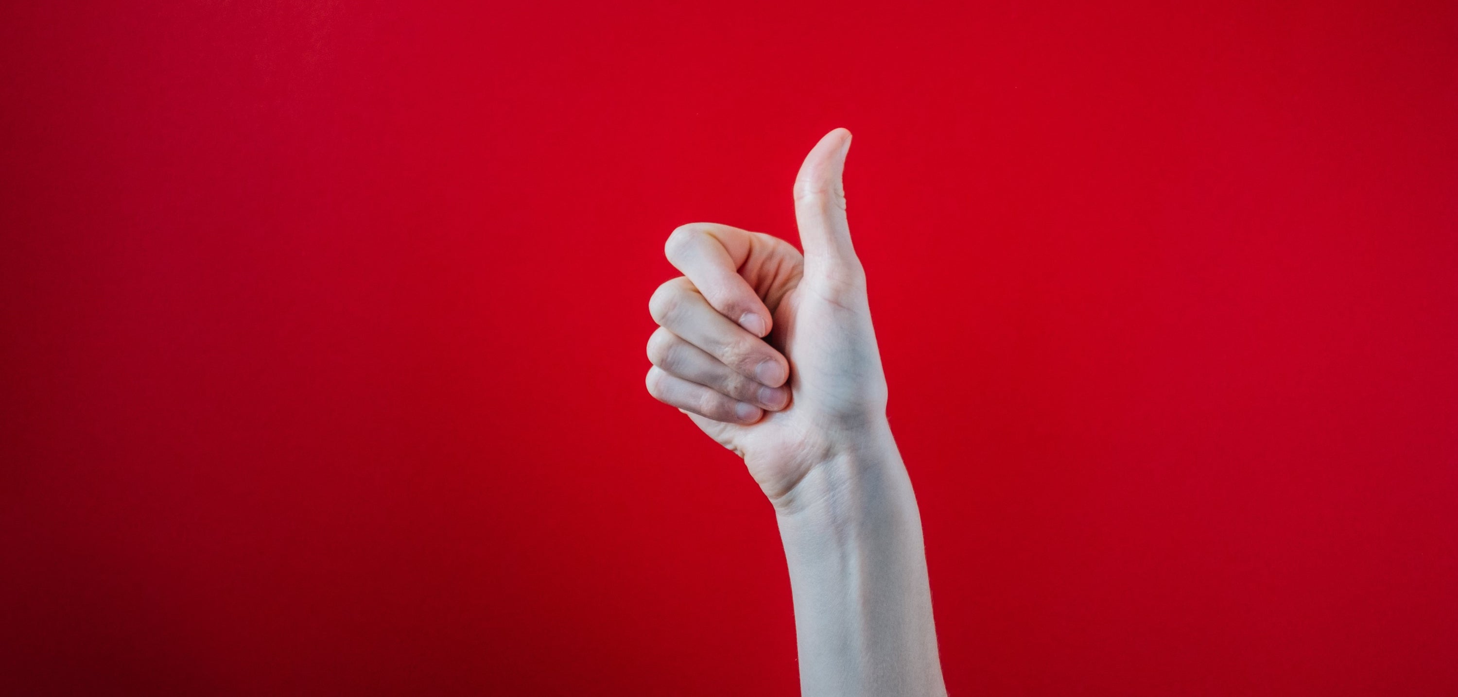 thumbs-up hand on red background