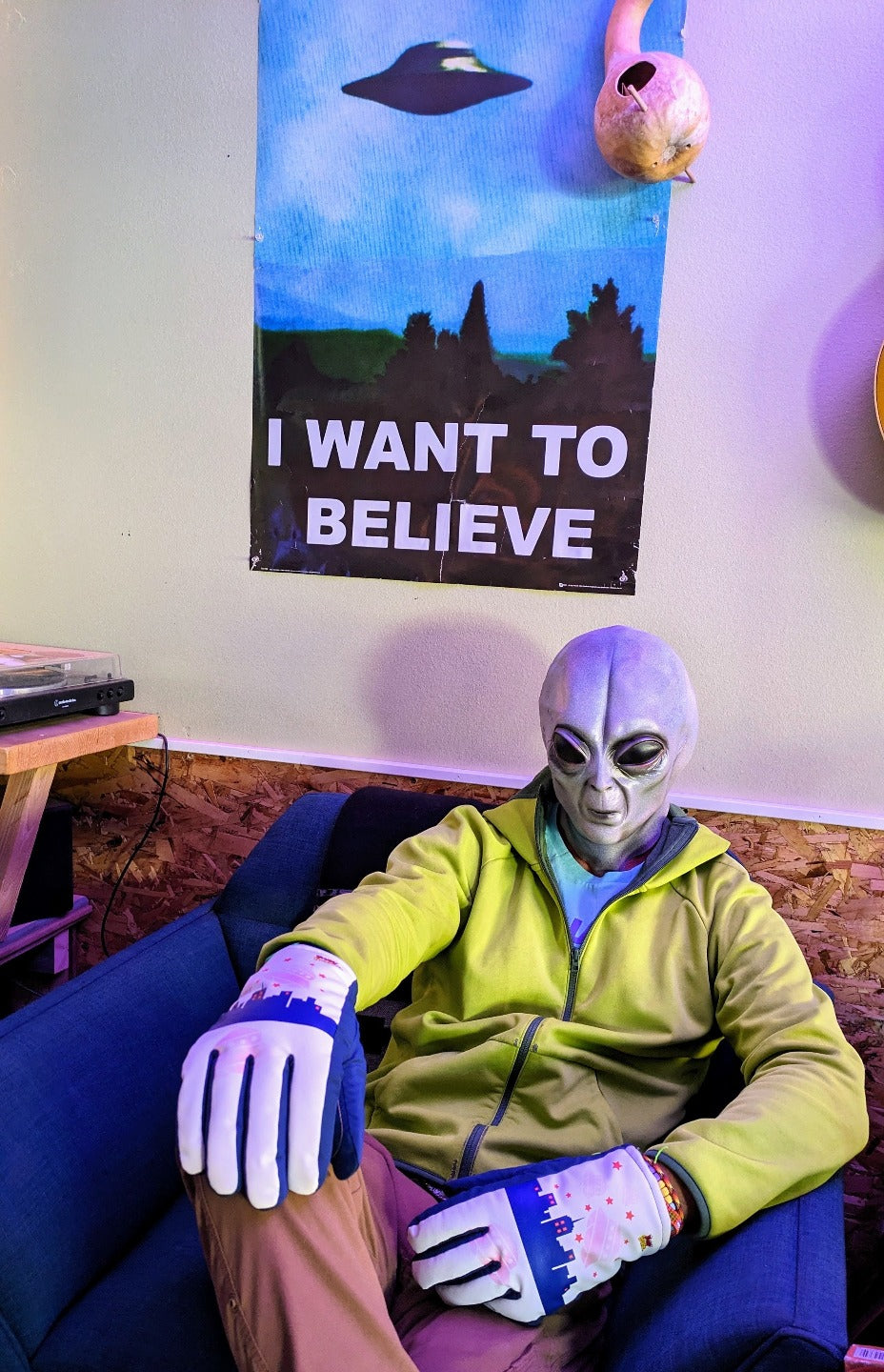 Alien wearing UFO Freezy Freakies below I want to believe poster